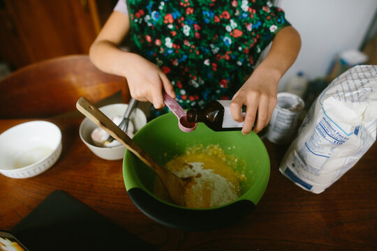 Overhead view of child mixing ingredients in a large bowl