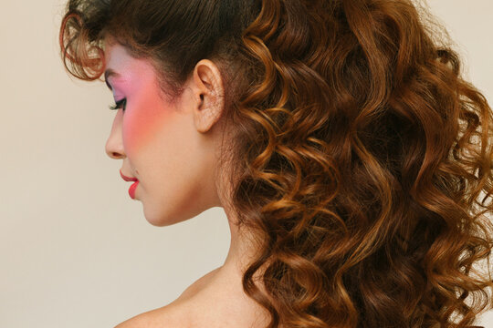 Woman with eighties make-up and long curly hair