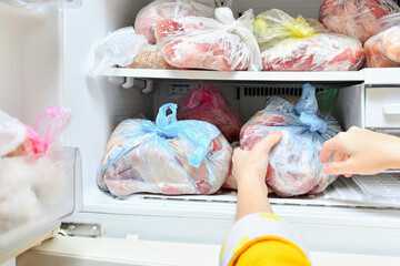 The hostess puts various food products packaged in bags into the freezer.
