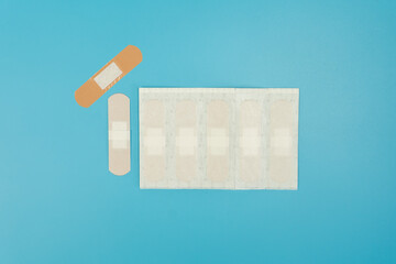 First aid sore plaster blue colored surface.