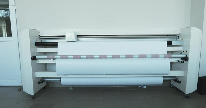 big white plotter printing job in polygraphy. printing on dimensional paper in production. hitting a steadicam. overall plan