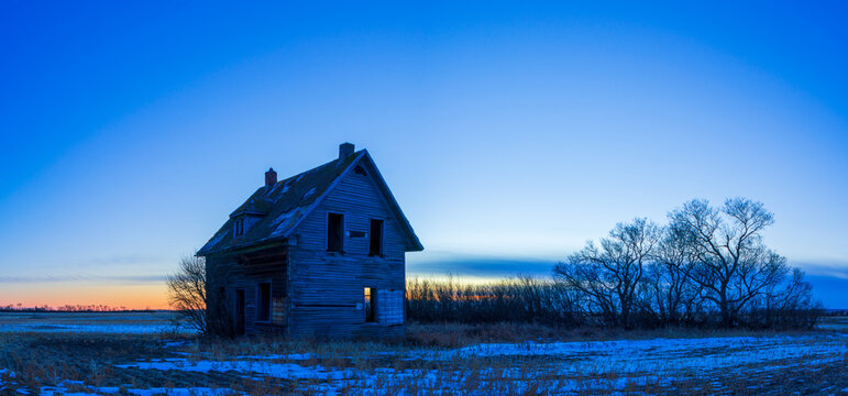 abandoned farmhouse in prairie 