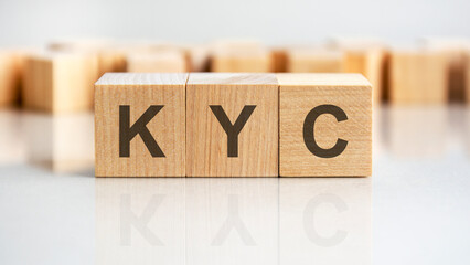 KYC - letters on wooden cubes. business as usual concept image. front view