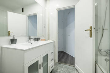 Fototapeta na wymiar Bathroom with white resin vanity unit and sink, frameless rectangular mirror and walk-in shower with screen