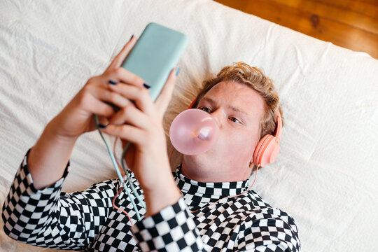 Young queer man using his phone