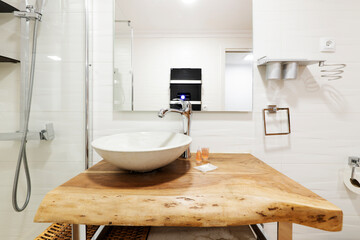 Fototapeta na wymiar Front image with a white shell sink on a wooden log countertop and a glazed shower stall, a white anti-fog square mirror