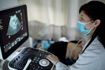 Female Chinese obstetrician performs an ultrasound 