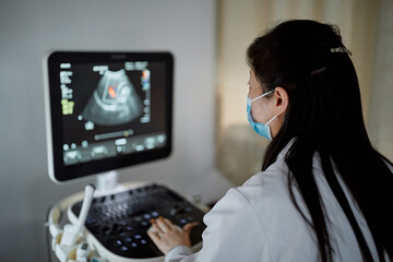 Female Chinese obstetrician performs an ultrasound 