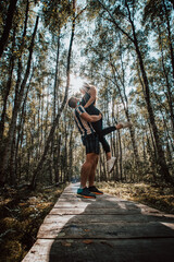 Couple in love hugging on duckboards in the middle of the Finnish wilderness. The joy of discovering Scandinavia. A girl looks down on her boyfriend. Real feelings in real life