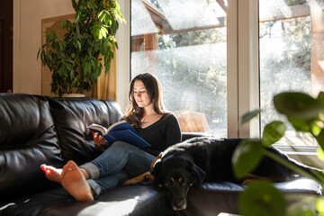 A Woman Reading Beside Her Dog