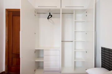Fototapeta na wymiar Open empty white closet layout with shelves, drawers and hanger rods