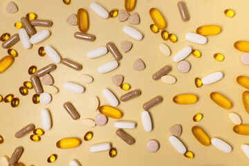 A lot of pills on a yellow background.