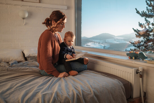 Woman Reading A Book To A Baby