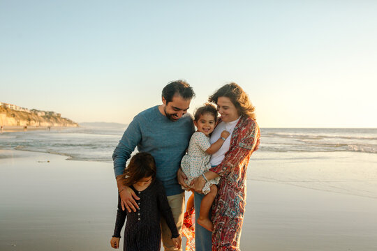 Joyful parents and two daughters at beach