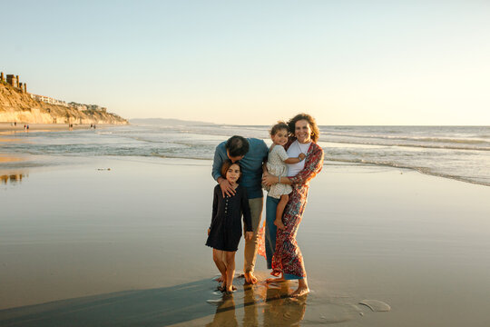 Happy mom, dad and two daughters at beach