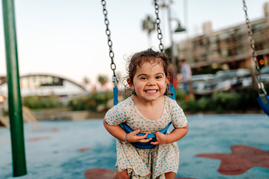 Smiling young girl leaning on swing
