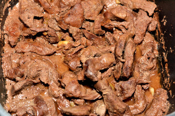 Selective focus of beef liver sliced in pieces and cooked with oil, white vinegar, black pepper,...