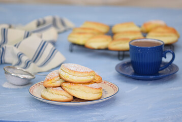 Fototapeta na wymiar Plate of tasty sochniki with cottage cheese on blue background.