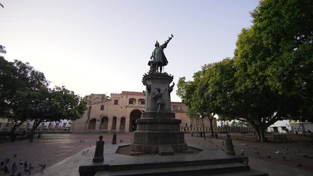 Moving around monument to Christopher Columbus at down. Pigeons fly in Columbus Park with no people. Santo Domingo, Dominican Republic	