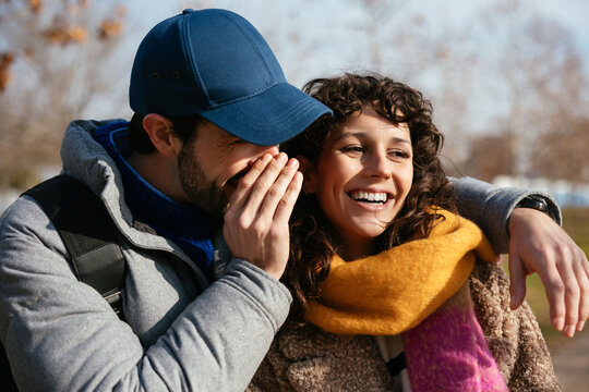 Man telling secret to woman in daytime