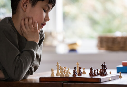 Little kid playing chess - Powered by Adobe