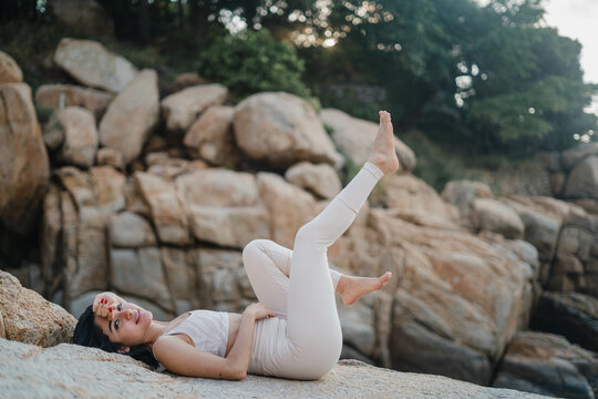 A young woman laying down on a rock