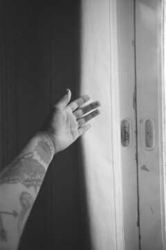 Hand letting bit of light come through curtains