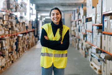 Smiling woman standing between racks in warehouse