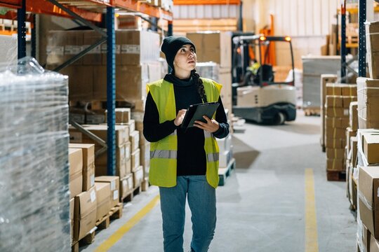 Female worker preparing order for delivery in warehouse - Powered by Adobe