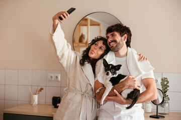 Content couple with dog taking self shot at home