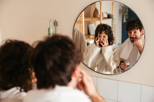 Couple doing daily beauty procedures in bathroom