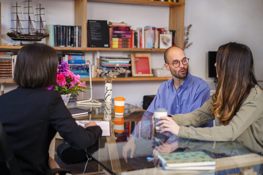 Sexologist writing on clipboard at session with couple