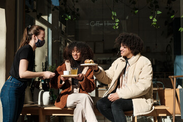 Waitress Serving food for Clients on cafe terrace