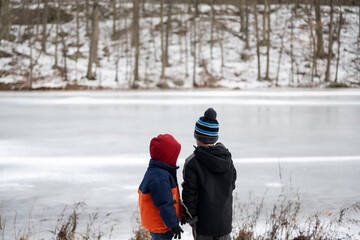 Kids standing in front of lake in winter