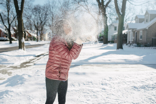 Black girl blowing a cloud of snow