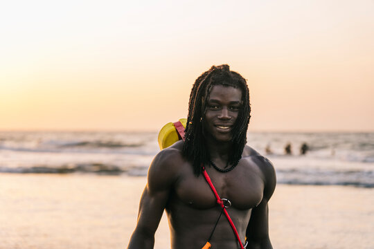 Content African rescuer on beach in evening
