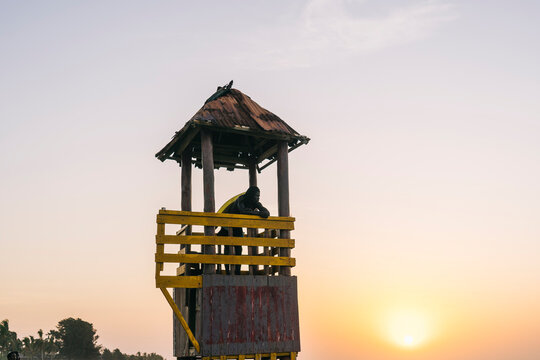 African lifeguard in rescue tower at seaside
