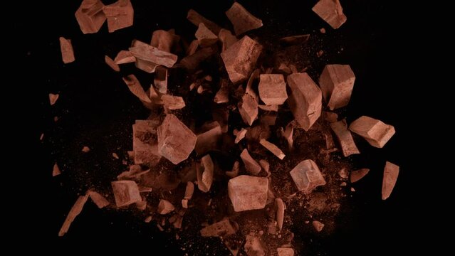Super slow motion of rotating group of raw chocolate pieces on black background. Filmed on high speed cinema camera, 1000fps.