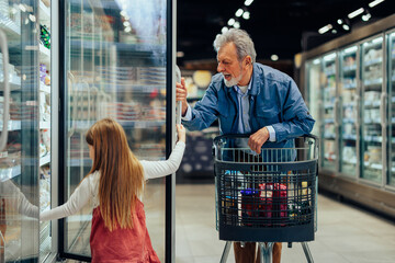 Girl and her grandfather at supermarket