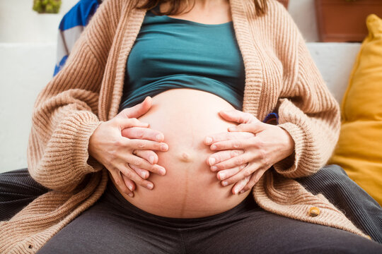 Parent's hands feeling pregnant belly