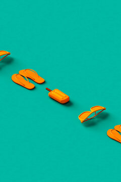 a row of flip flops, sunglasses and ice lolly. 