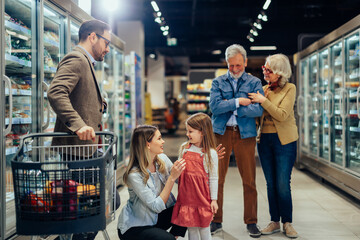 Fototapeta na wymiar Three generations family shopping in modern supermarket