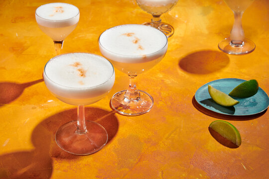 Cocktails in Coupe Glasses with Foam and Limes