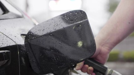 Man pumping gas into gas tank.