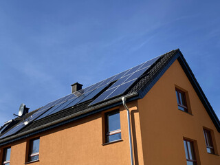 Fototapeta na wymiar Solaranlage an einem Einfamilienhaus mit blauem Himmel in Bielefeld, Nordrhein-Westfalen, Deutschland 