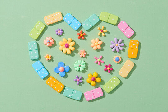 Dominoes lying in heart shape filled with flowers
