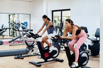 Young women riding bikes at the gym