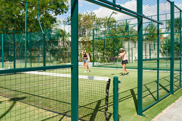 Women playing pedal inside of an outdoor court