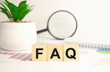 Faqs concept with wooden block on wooden table background.