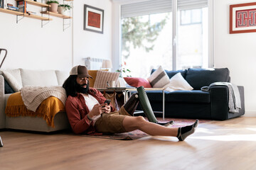 Handicap male using smartphone near sofa